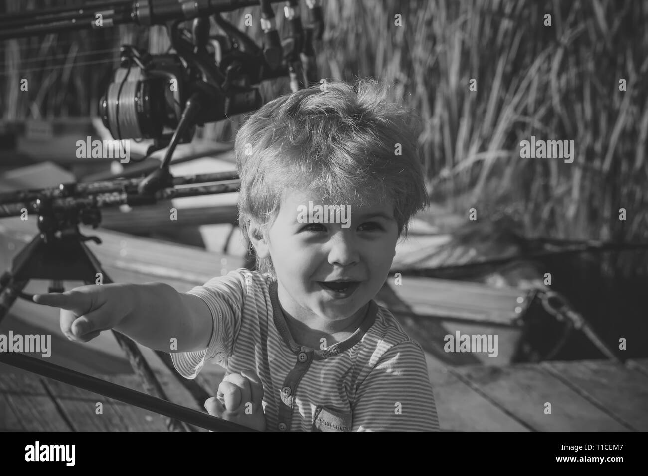 Little Boy punto dito sul lago o fiume Foto Stock