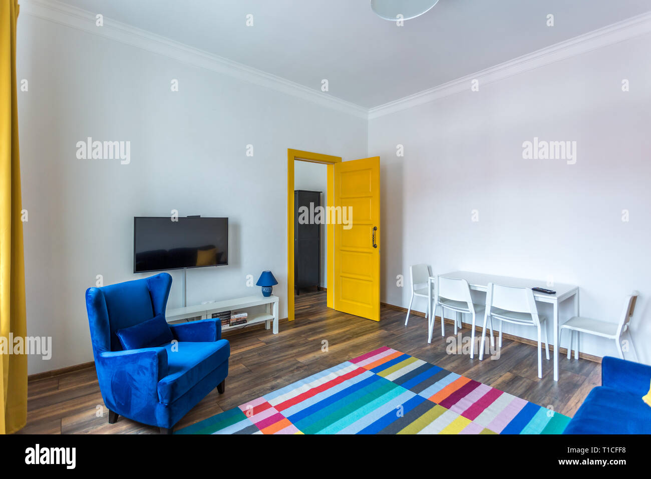 MINSK, Bielorussia - Marzo, 2019: retro interni luminosi di hipster appartamento appartamenti con divano blu, gialla porta e tappeti colorati Foto Stock