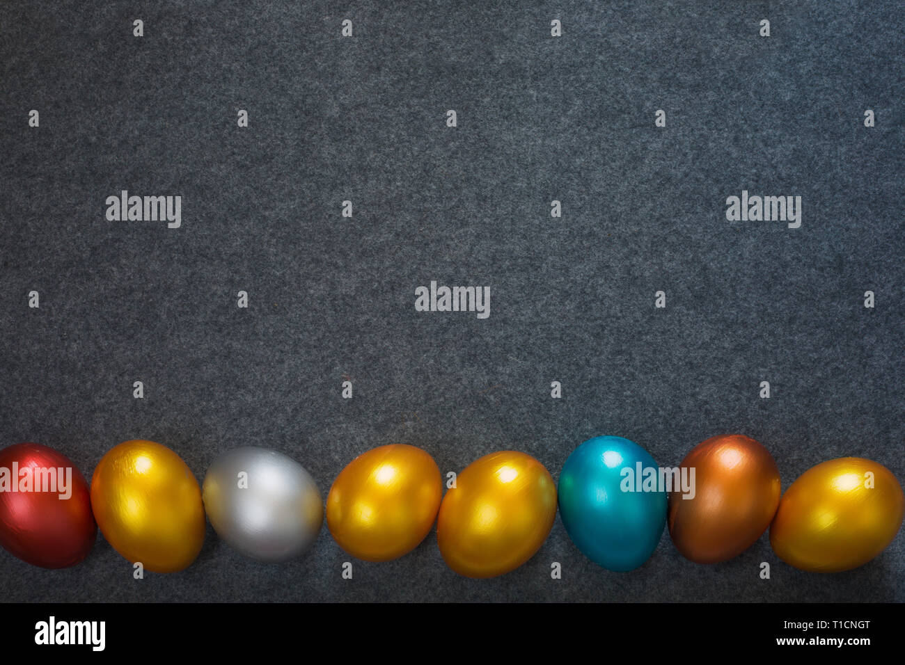 Moda elegante sfondo con telaio di confine di colore decorativi metallici le uova di Pasqua su sfondo tessili, copia spazio per il testo. Vista superiore laici piatta Foto Stock