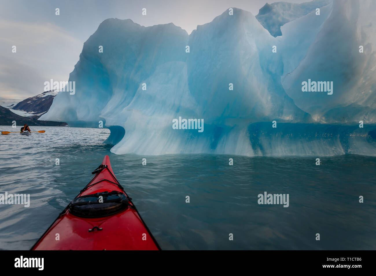 Kayaker pale blu turchese iceberg presso sunrise in acque pericolose dell'Alaska Foto Stock