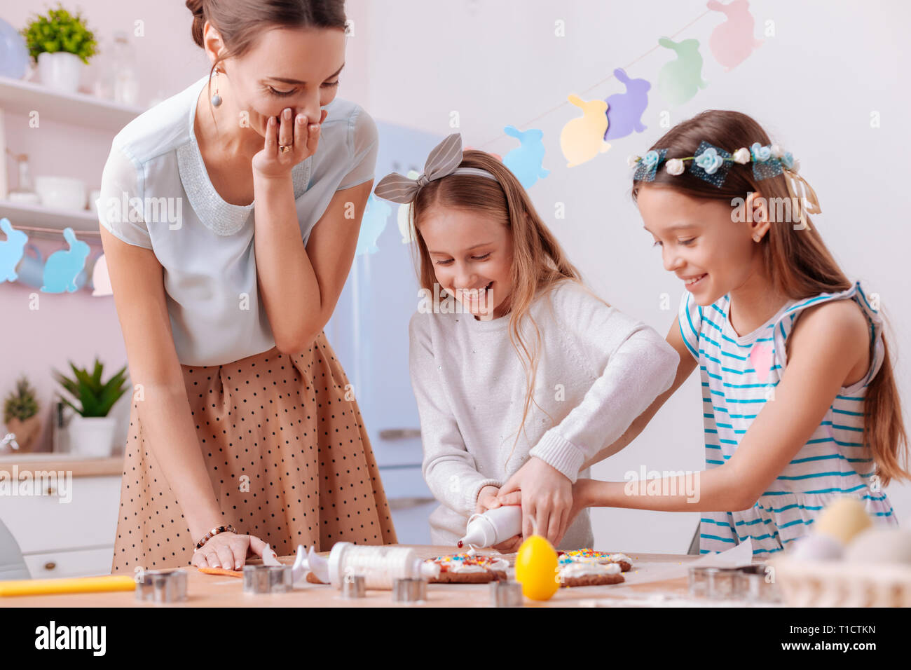 Positive le ragazze felici divertendosi in cucina Foto Stock