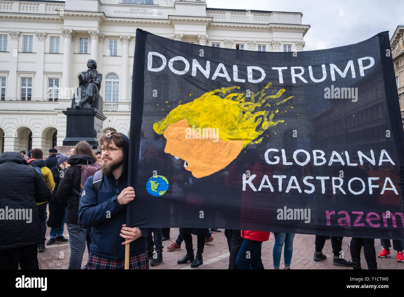 Uno hipster-style protester con anti-Trump 'DDonald Trump - disastro globale' banner durante l'anti-dimostrazione razzista a Varsavia in Polonia. Foto Stock