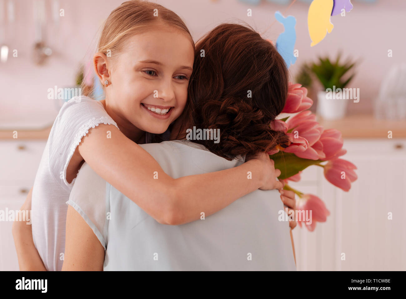 Felice adolescente bionda abbracciando la sua giovane mamma Foto Stock