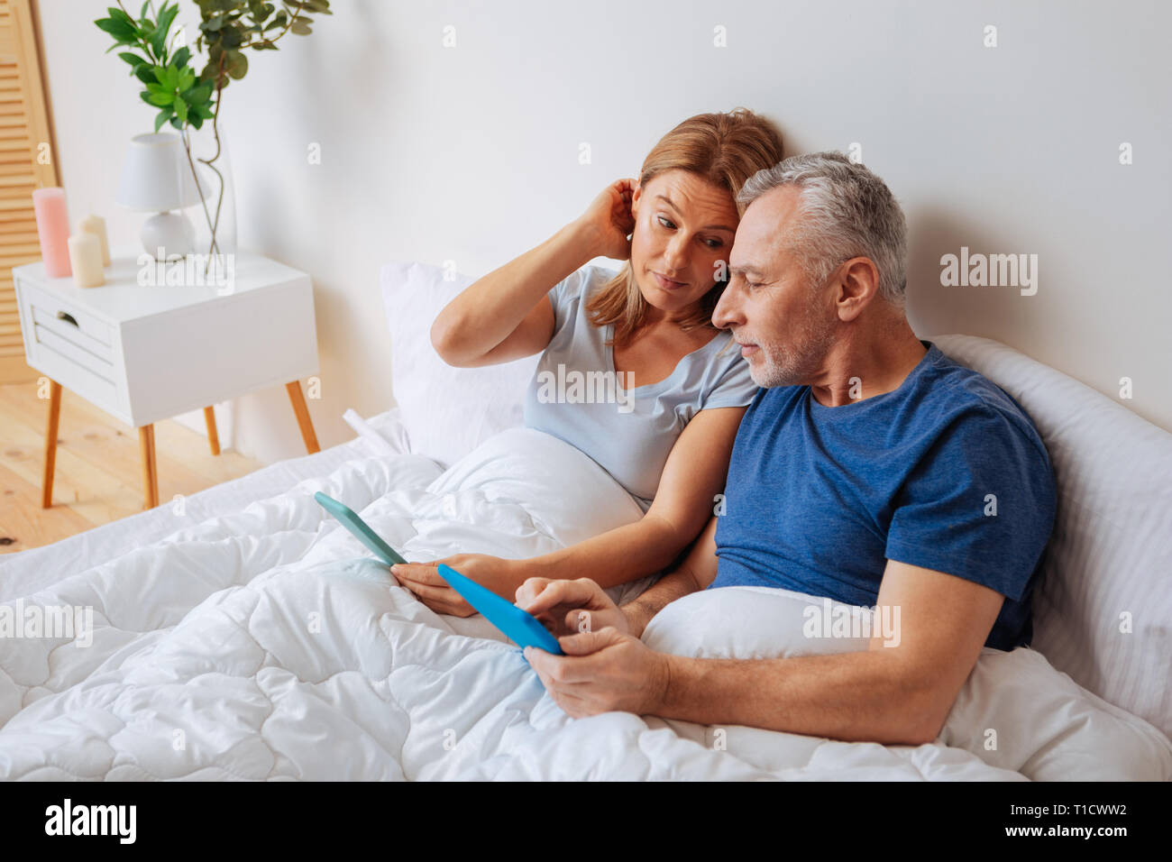 Imprenditori maturi utilizzando le loro compresse di lavoro di lettura e-mail Foto Stock