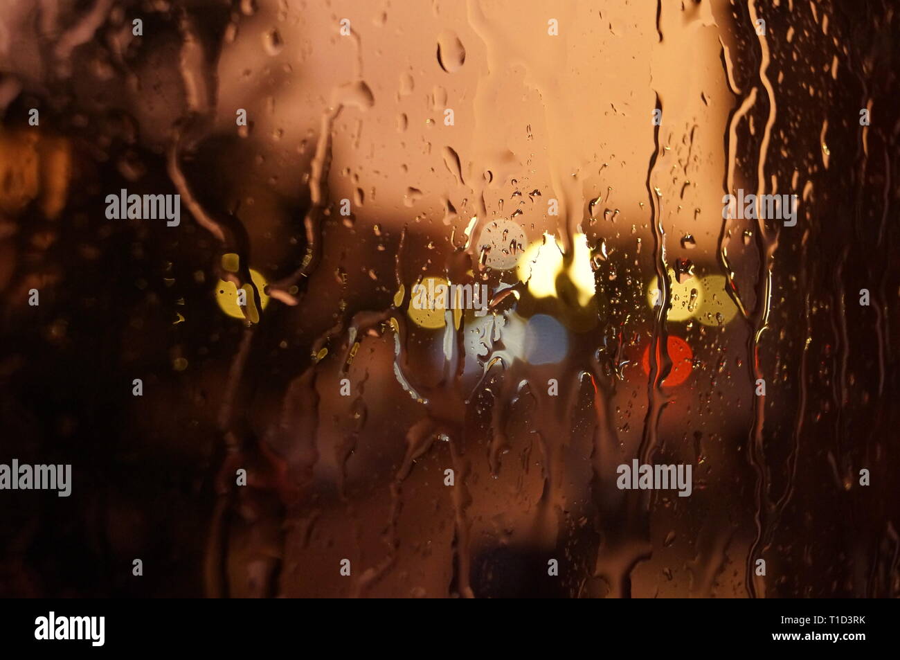 La luminosità del tramonto di gocce d'acqua sulla finestra Foto Stock
