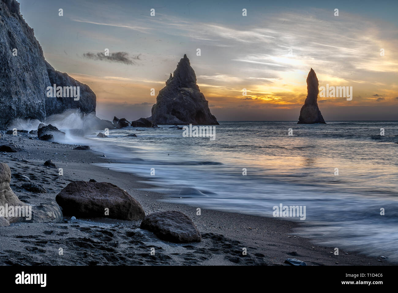 Reynisdrangar basalto pile di mare e il Reynisfjara spiaggia di sabbia nera,Vík, Islanda Foto Stock