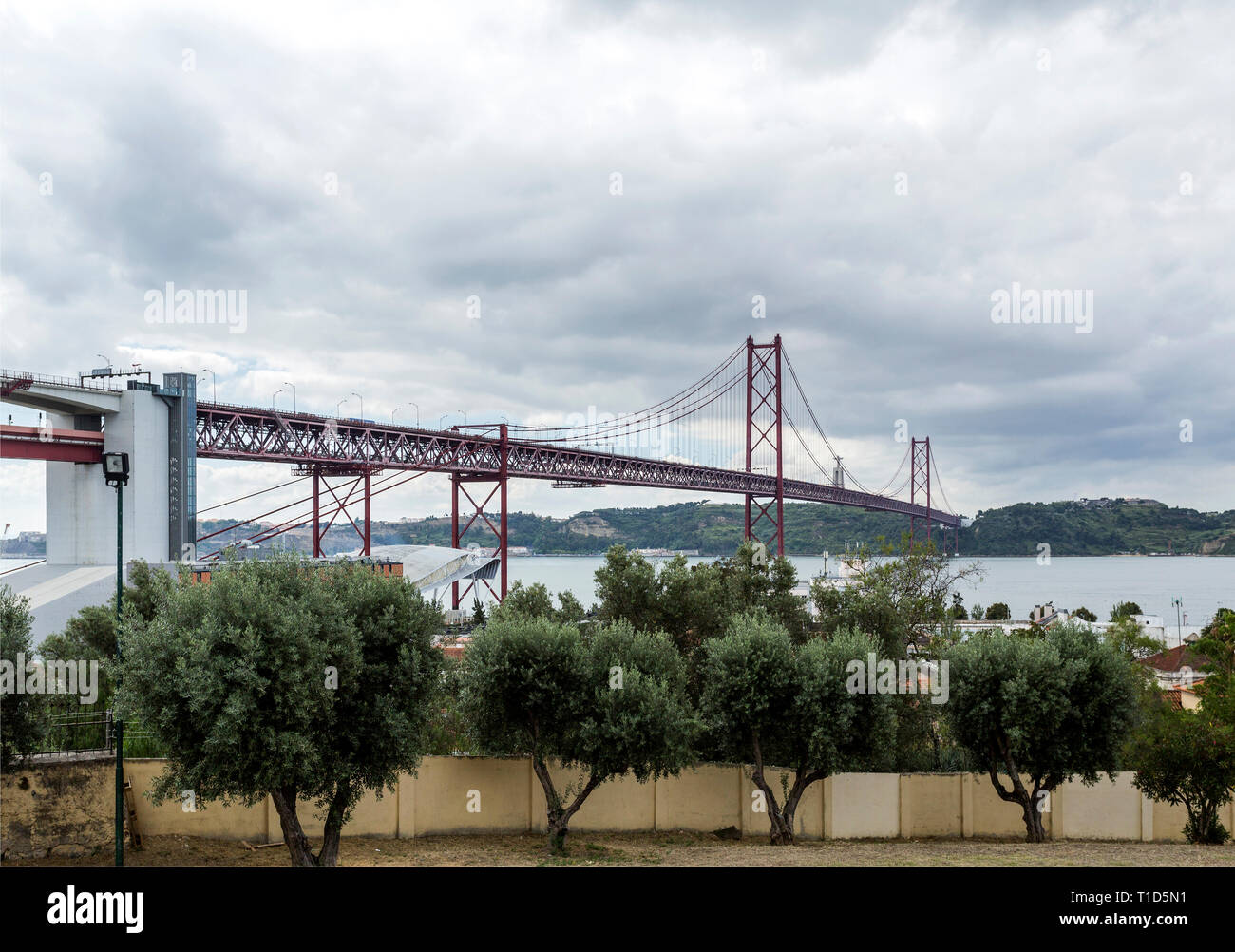 Vista del XXV Aprile ponte di sospensione, dipinta di arancione internazionale ed è stato inaugurato nel mese di agosto 1966, attraversando il fiume Tago a Lisbona, Portu Foto Stock