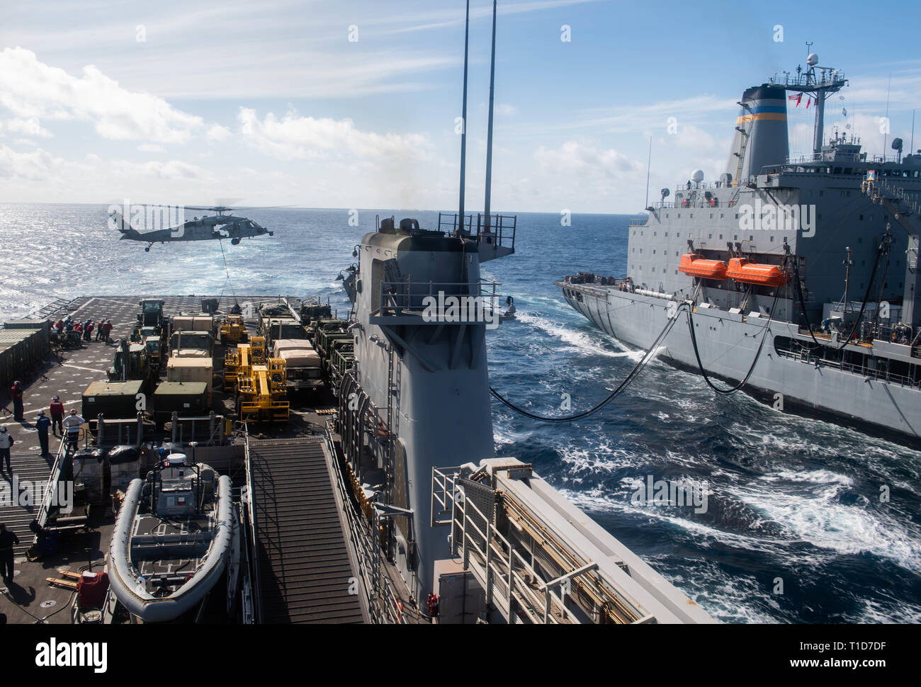 190323-N-HD110-0069 OCEANO PACIFICO (23 marzo 2019) un MH-60S Sea Hawk elicottero, attaccato al mare in elicottero Combat Squadron (HSC) 21, scende fornisce sul ponte di volo dell'harpers Ferry-classe dock anfibio sbarco nave USS harpers Ferry (LSD 49) durante un rifornimento in mare con la flotta oliatore di rifornimento USNS Yukon (T-AO 202). Harpers Ferry è in corso conducendo le operazioni di routine come una parte di USS Boxer anfibio gruppo pronto (ARG) nell'Oceano Pacifico orientale. (U.S. Foto di Marina di Massa lo specialista di comunicazione di terza classe Danielle A. Baker) Foto Stock