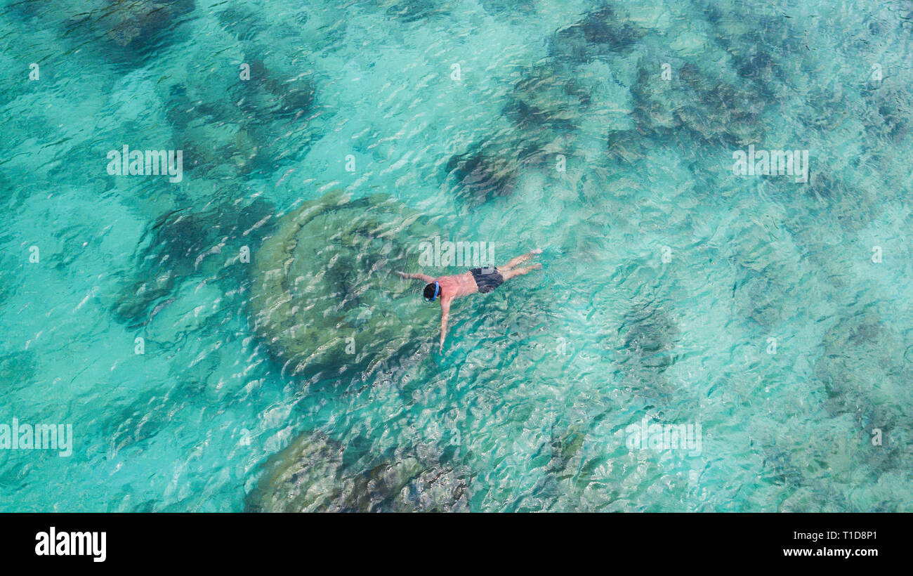 Turismo vacanza snorkeling piscina uomo snorkeling in paradiso acqua chiara. Nuotare boy snorkeler in acque cristalline e barriere coralline. Oceano turchese ba Foto Stock