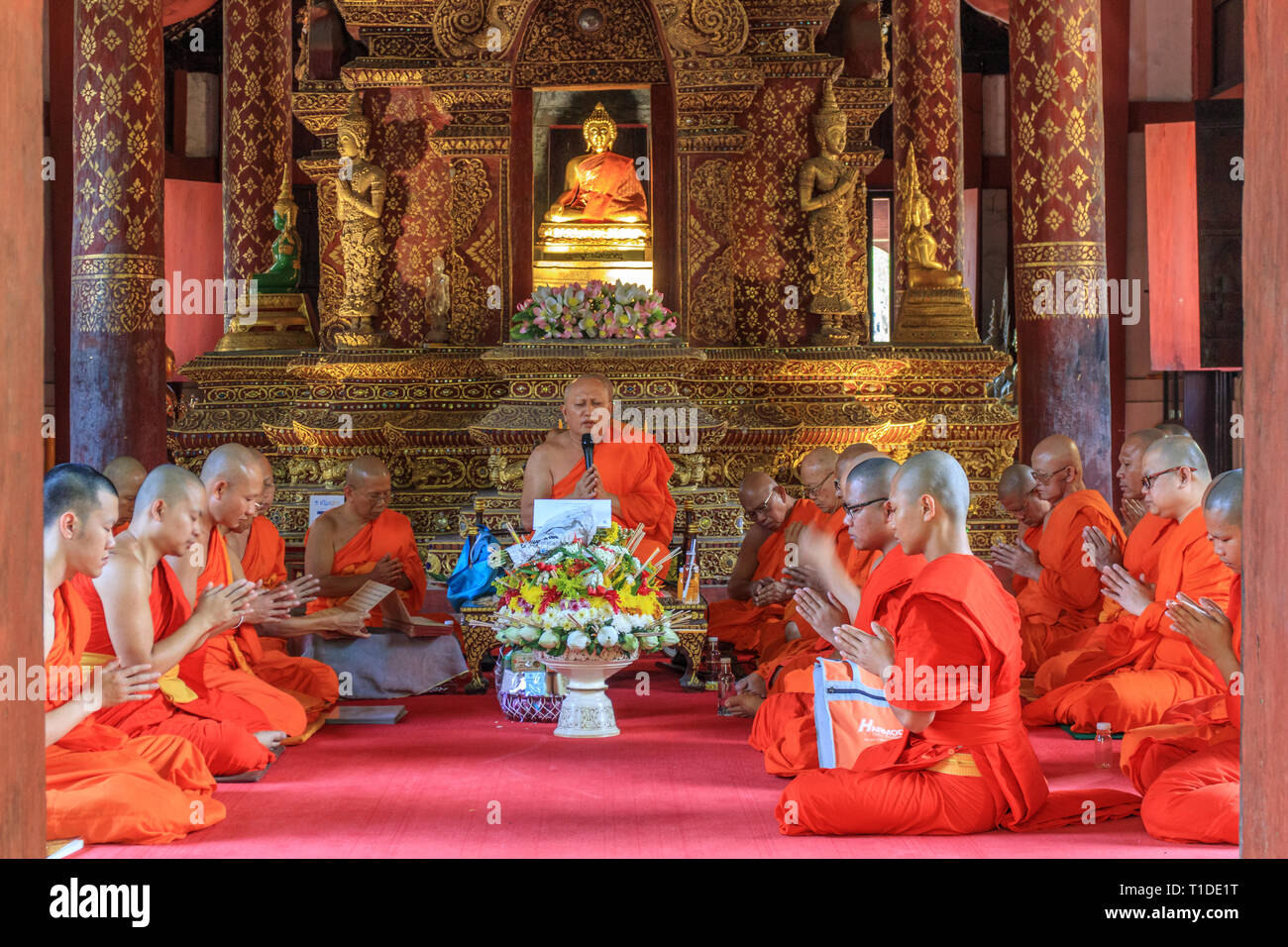Un gruppo di monaci raccolti in preghiera all'interno del Wat Pra cantare tempio Foto Stock