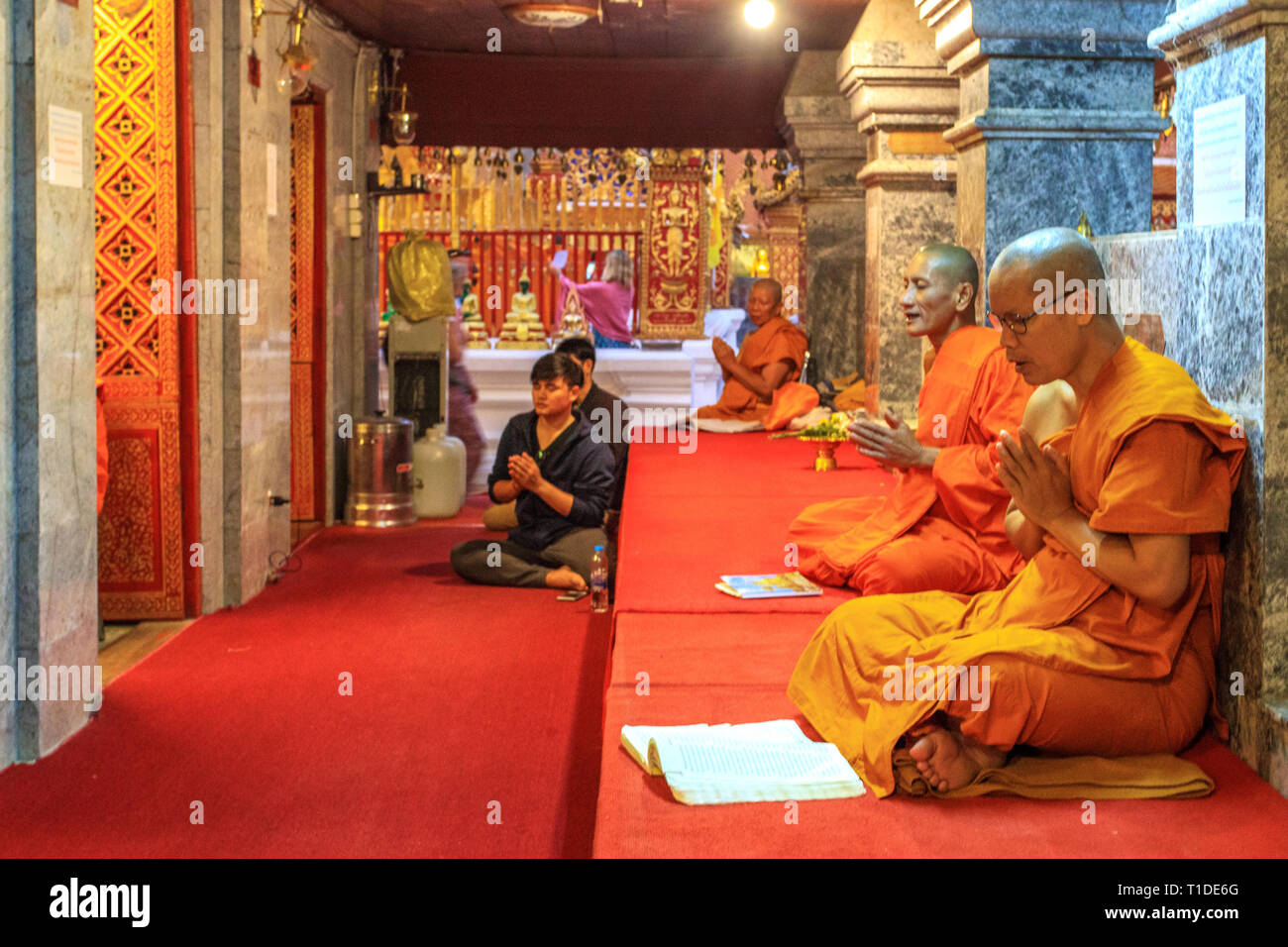 I monaci raccolti in preghiera all'interno del Wat Phrathat Doi Suthep Temple Foto Stock