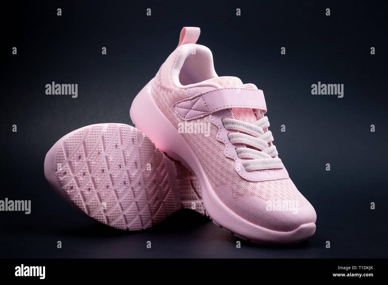Senza marca rosa scarpe da corsa su uno sfondo nero Foto Stock
