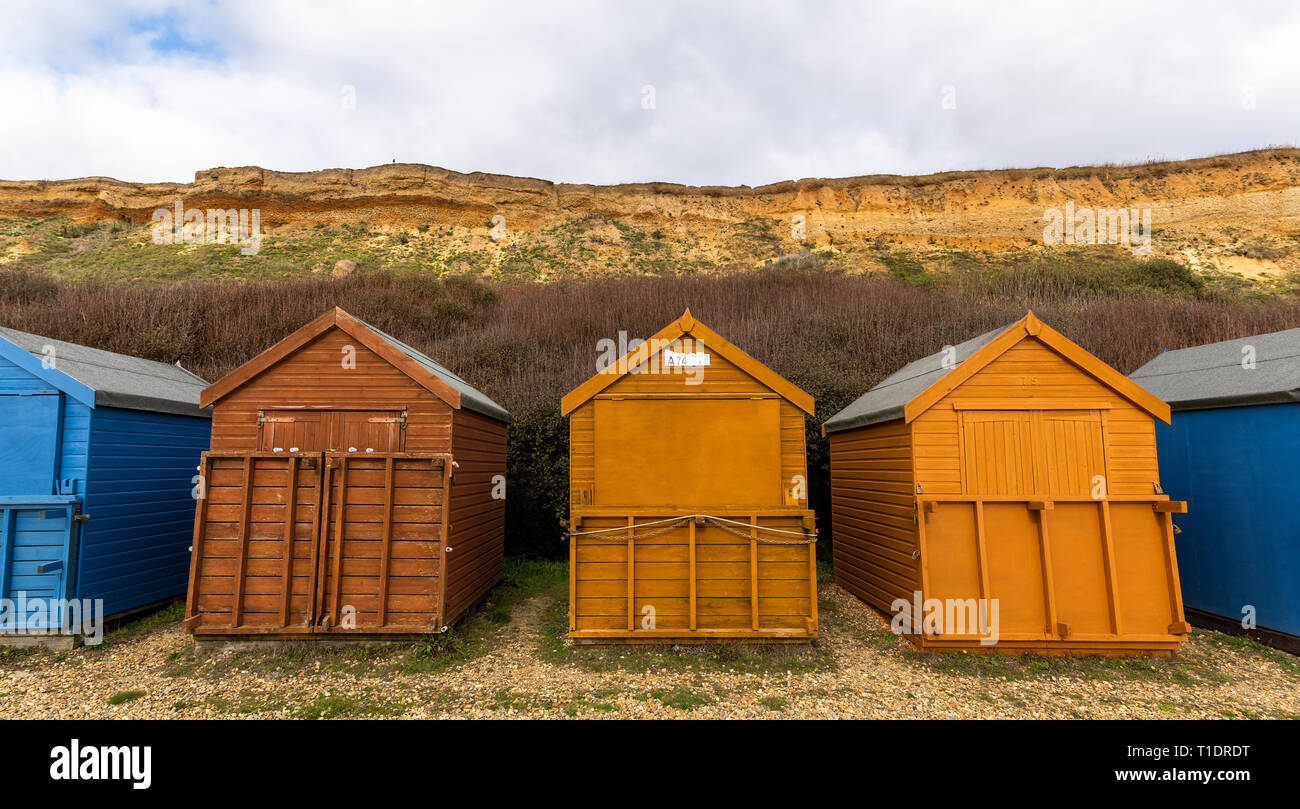 Blu e marrone case sulla spiaggia durante la stagione autunnale con chiuse le finestre e le porte in Barton sul mare, Engalnd Foto Stock