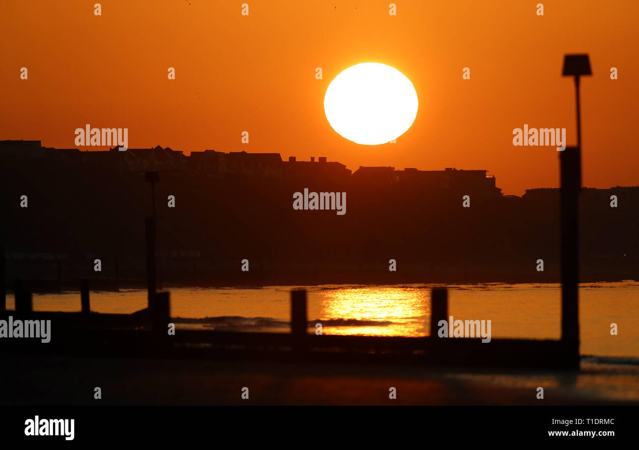 Il sole sorge sulla spiaggia di Boscombe nel Dorset. Foto Stock