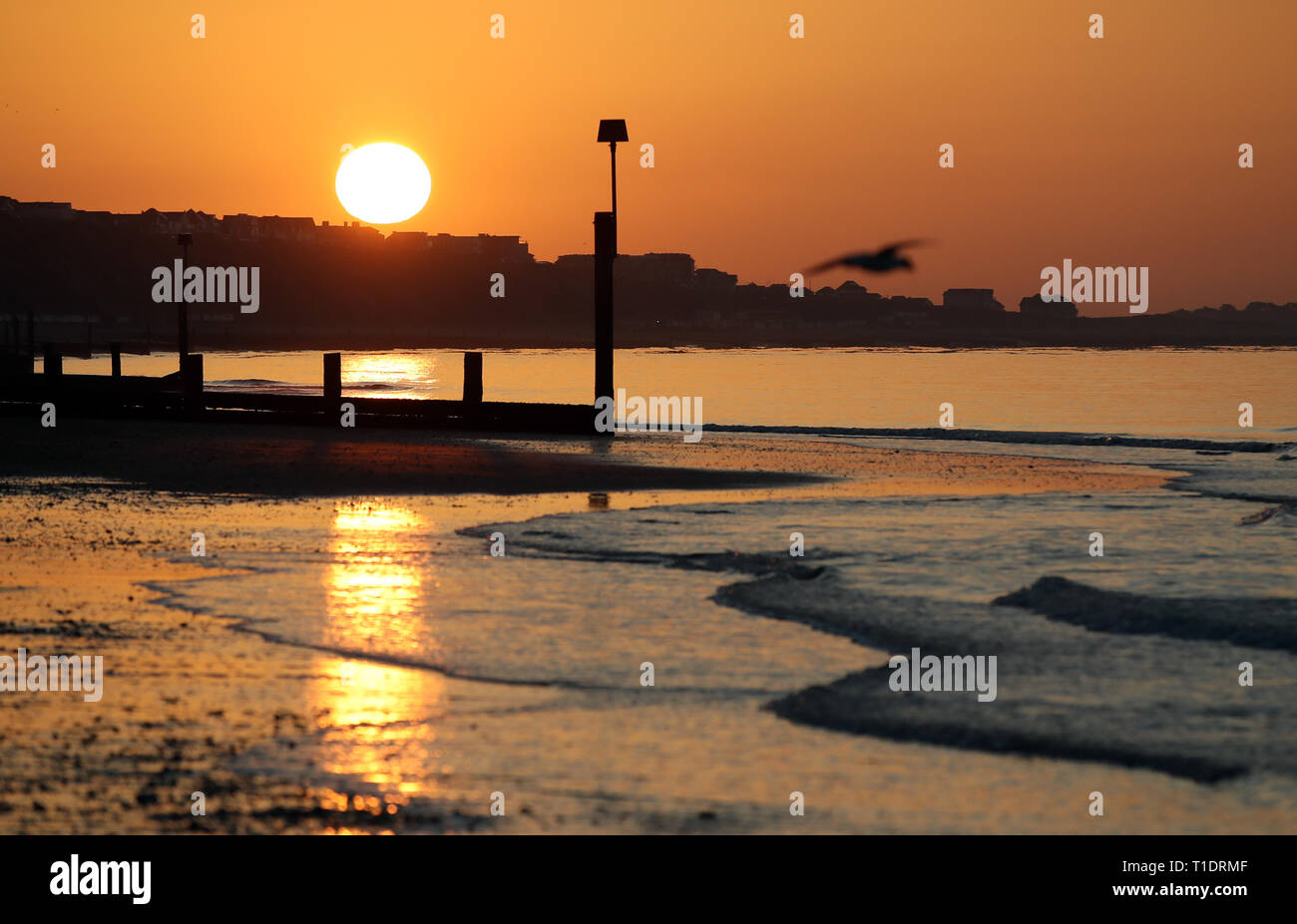 Il sole sorge sulla spiaggia di Boscombe nel Dorset. Foto Stock