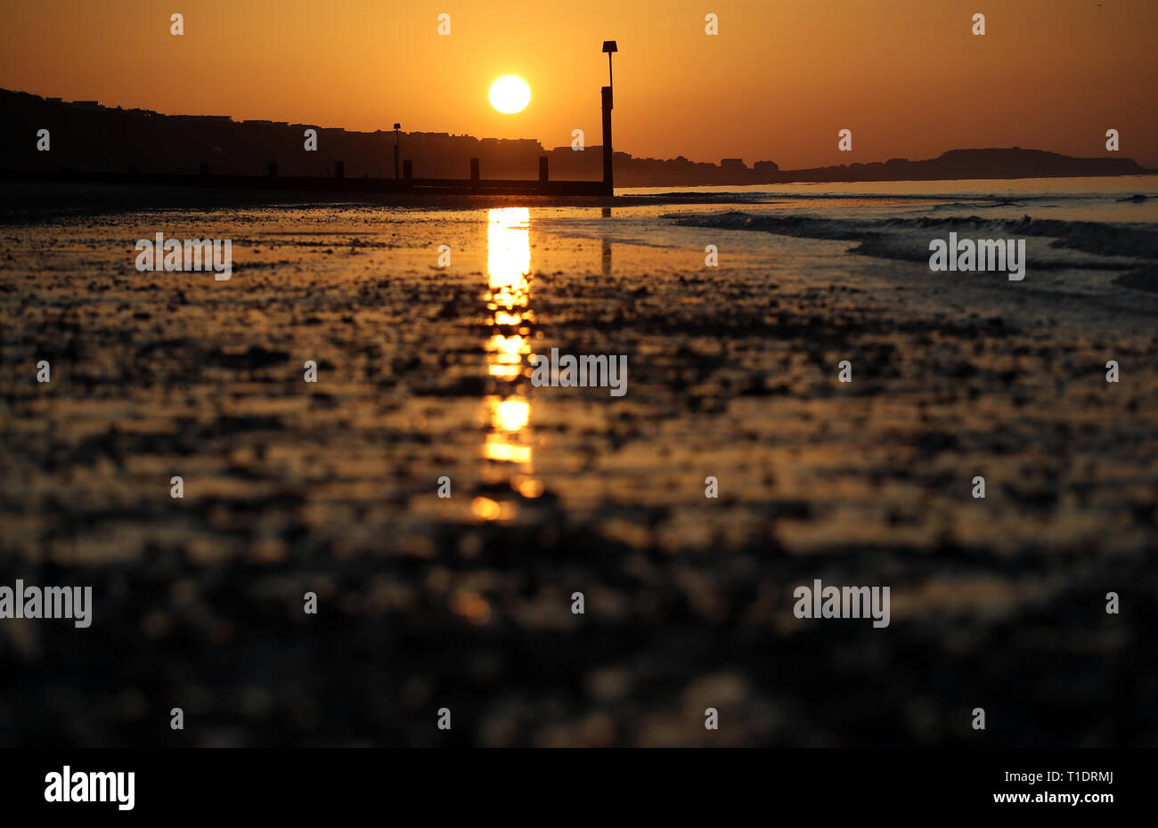 Il sole sorge sulla spiaggia di Boscombe nel Dorset. Foto Stock