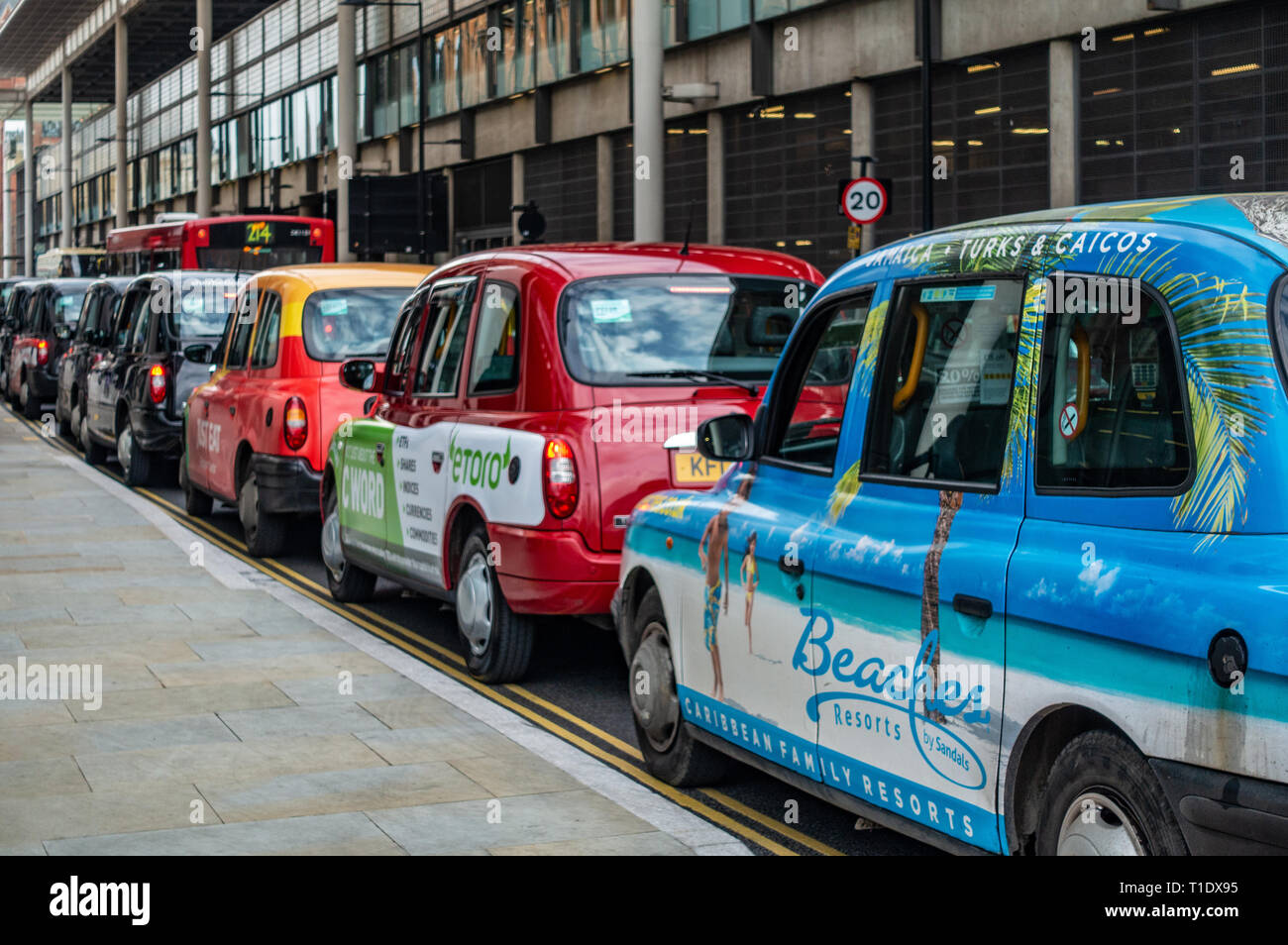 Lunga fila di taxi in attesa in una coda per la Stazione Ferroviaria di King's Cross punto di prelievo Foto Stock