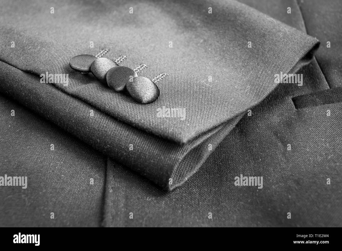 Pulsanti sui manicotti di grigio di una tuta blazer Foto Stock
