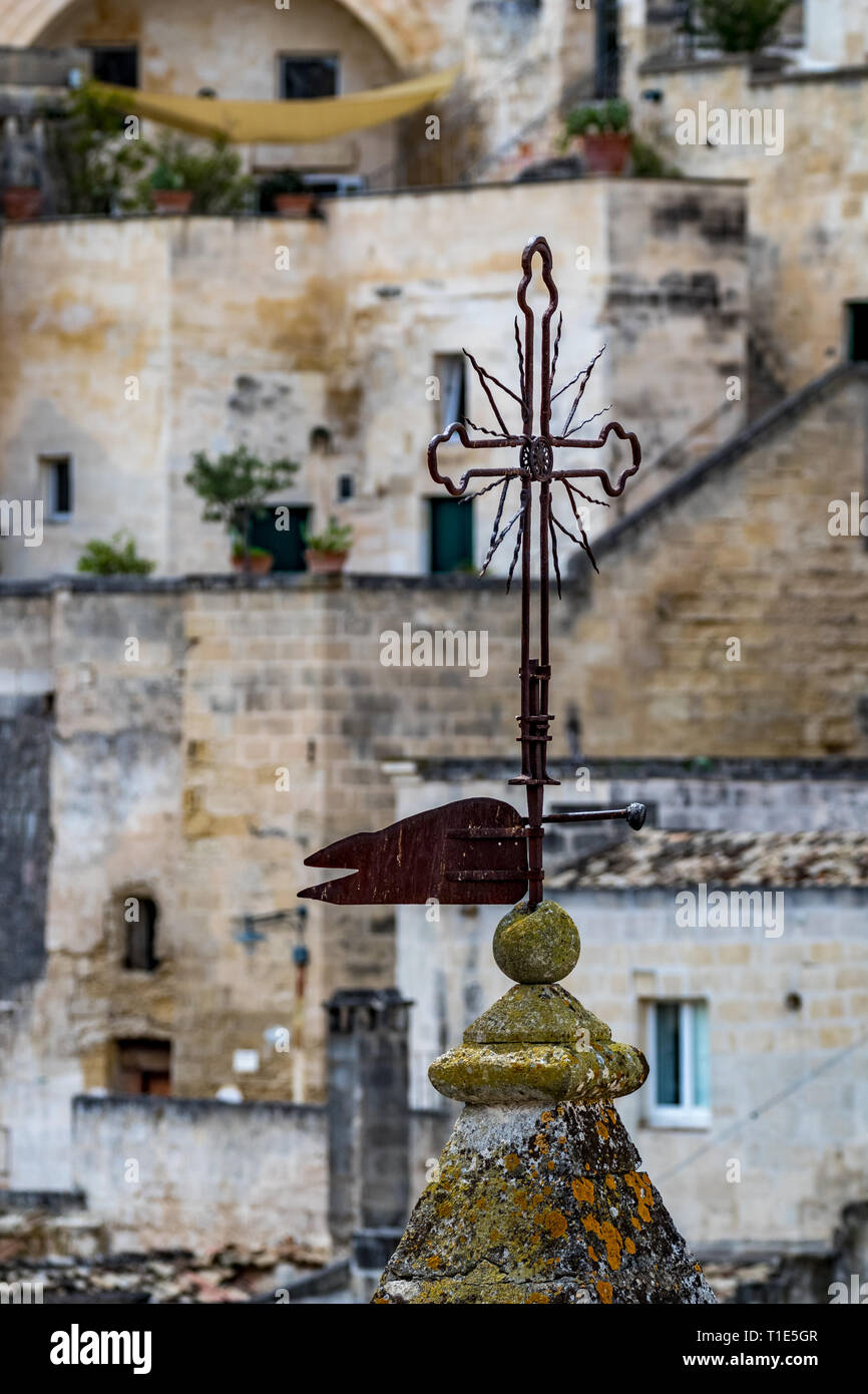 Giorno di estate scenario Street View di un artistico metallico croce cristiana sul sorprendente antica città dei Sassi con sfondo sfocato di disegno o Foto Stock