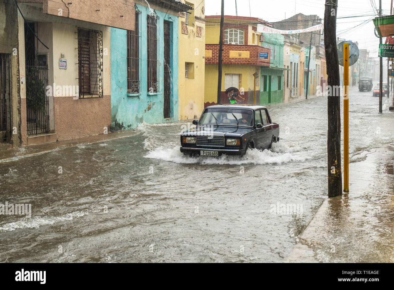 Santa Clara, Cuba - 5 Marzo 2019: una guida auto una strada inondata dall'acqua piovana a causa di pioggia intensa Foto Stock