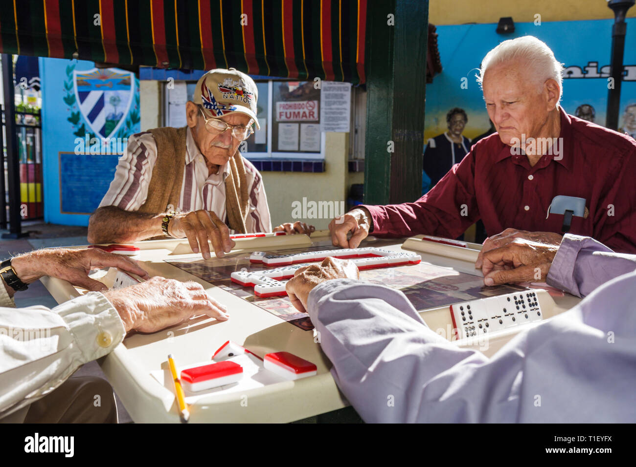 Miami Florida,Little Havana,Calle Ocho,Maximo Gomez Domino Park,uomo ispanico uomini maschi,anziani cittadini,foursome,gruppo,domino,tegole,gam Foto Stock