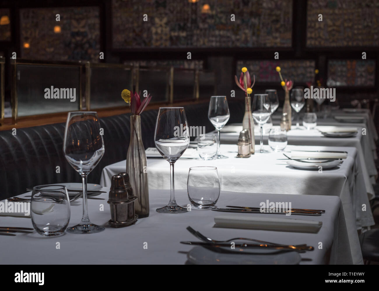 Interno di un moderno ristorante con tavoli serviti a cena Foto Stock