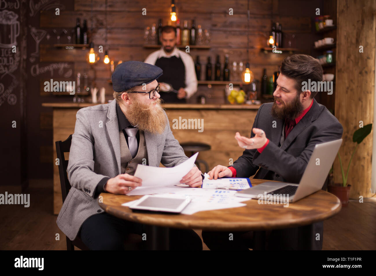 Due economisti barbuto avente un incontro di affari in un coffee shop. Uomini caucasici. Uomini belli. Un buon lavoro di squadra. Foto Stock