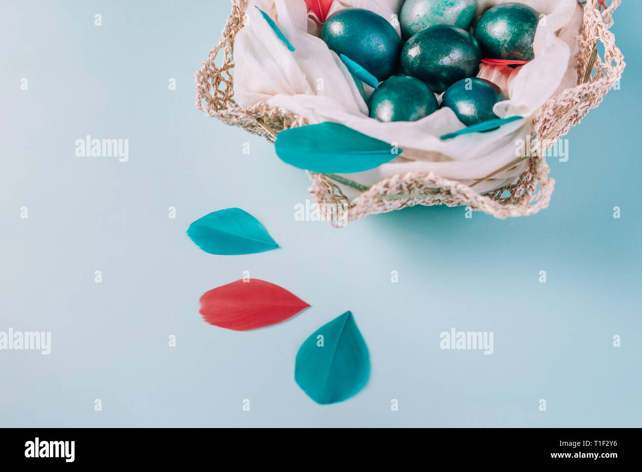 Sfondo di pasqua con uova decorate in blu, turchese e oro nel nido con le piume colorate. Close-up. Copia dello spazio. Foto Stock