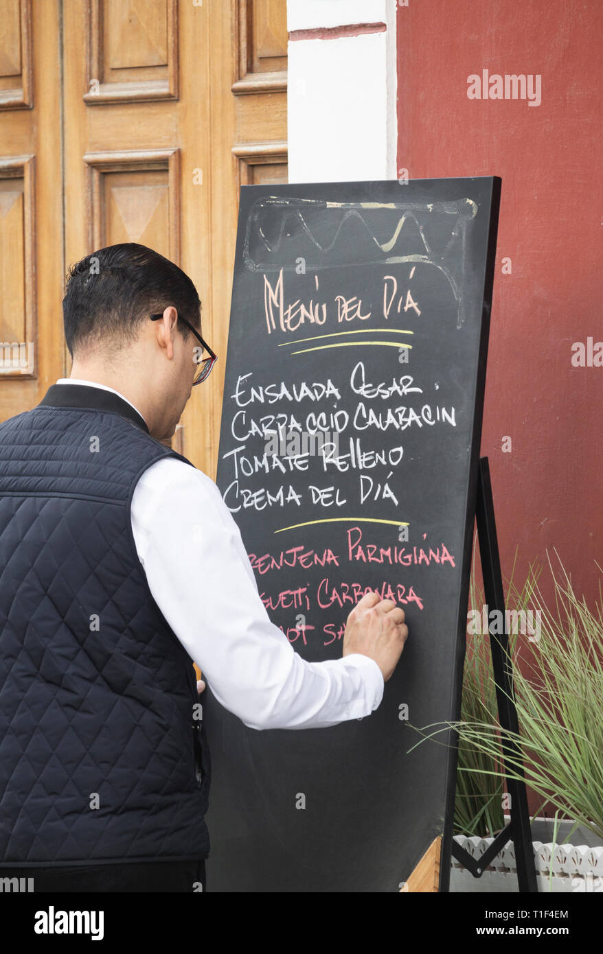 Cameriere Menu scrittura del dia, [menu del giorno] sulla lavagna fuori del ristorante in Vegueta, Las Palmas di Gran Canaria Isole Canarie Spagna Foto Stock
