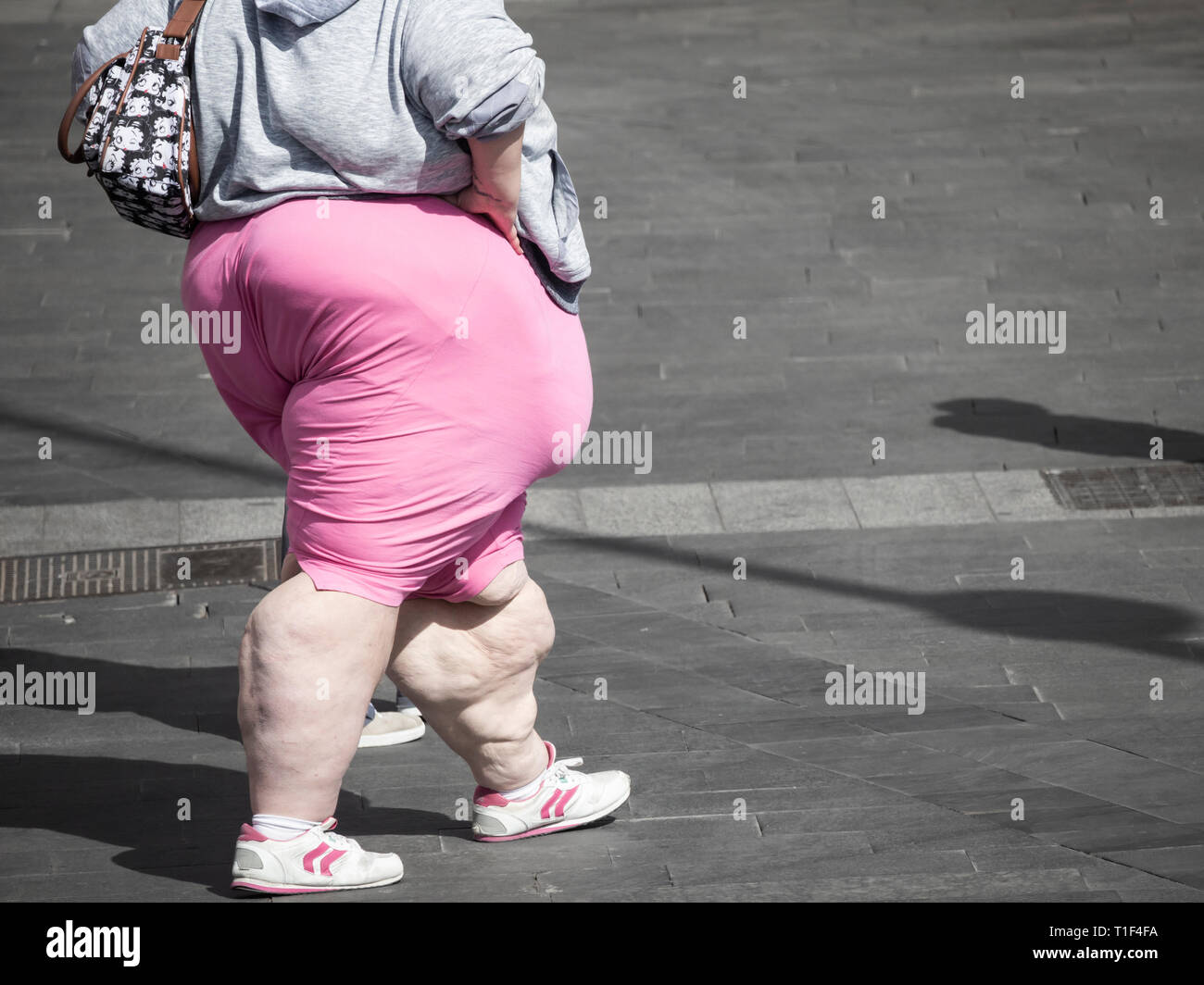 Obesi giovane donna a piedi in centro citta'. Foto Stock