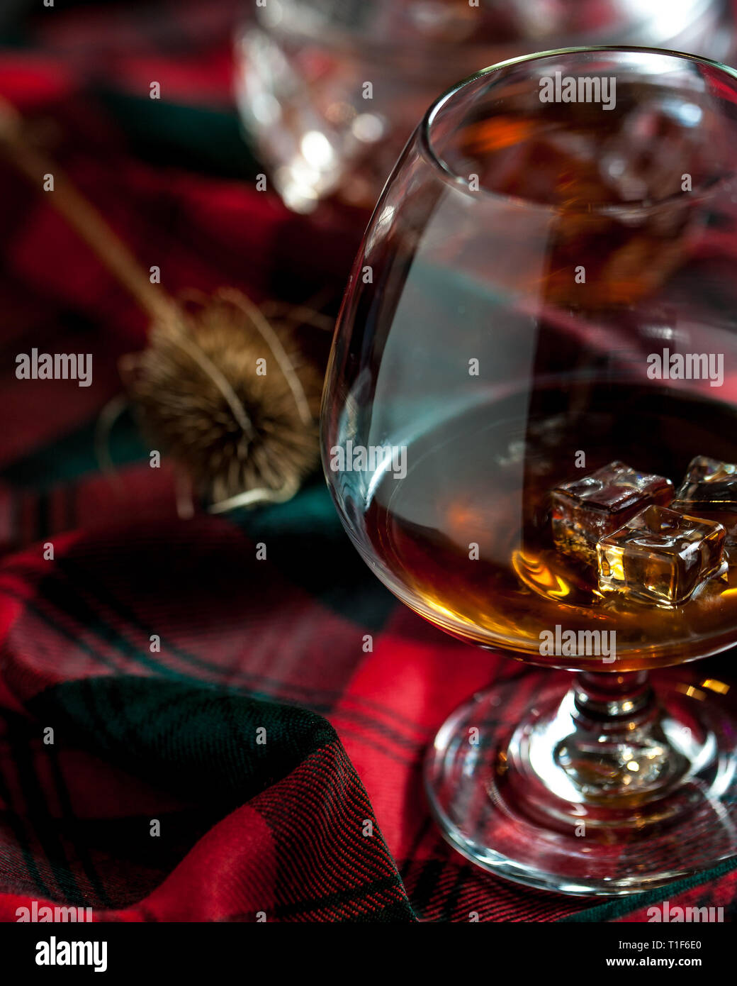 Bicchiere di whisly scozzese su una tabella con i tradizionali tartan e un thisly, simbolo della Scozia Foto Stock