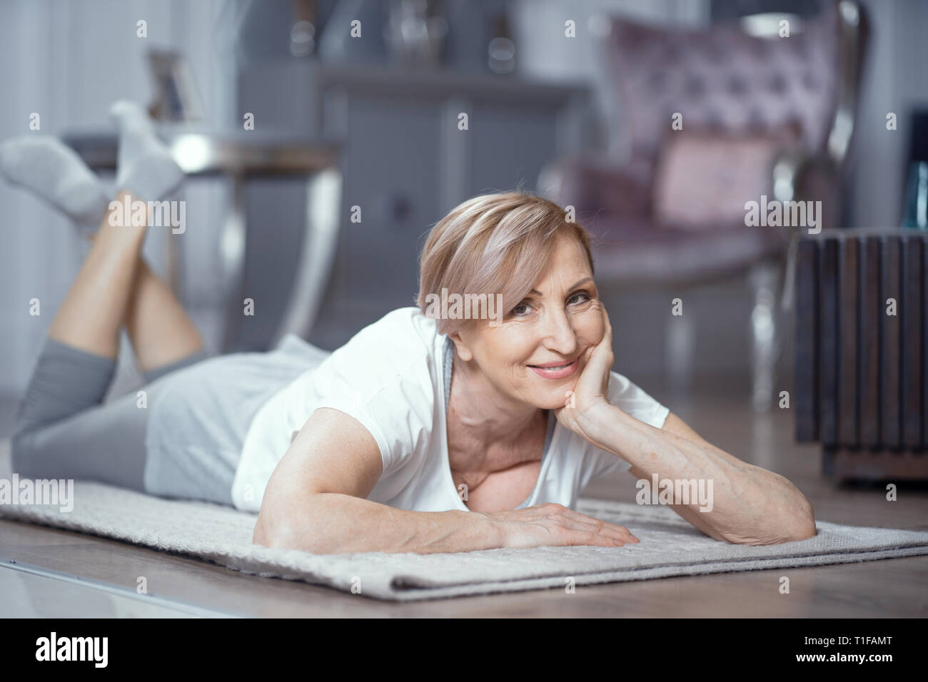 Medio - età donna fare esercizio con il tappetino Foto Stock