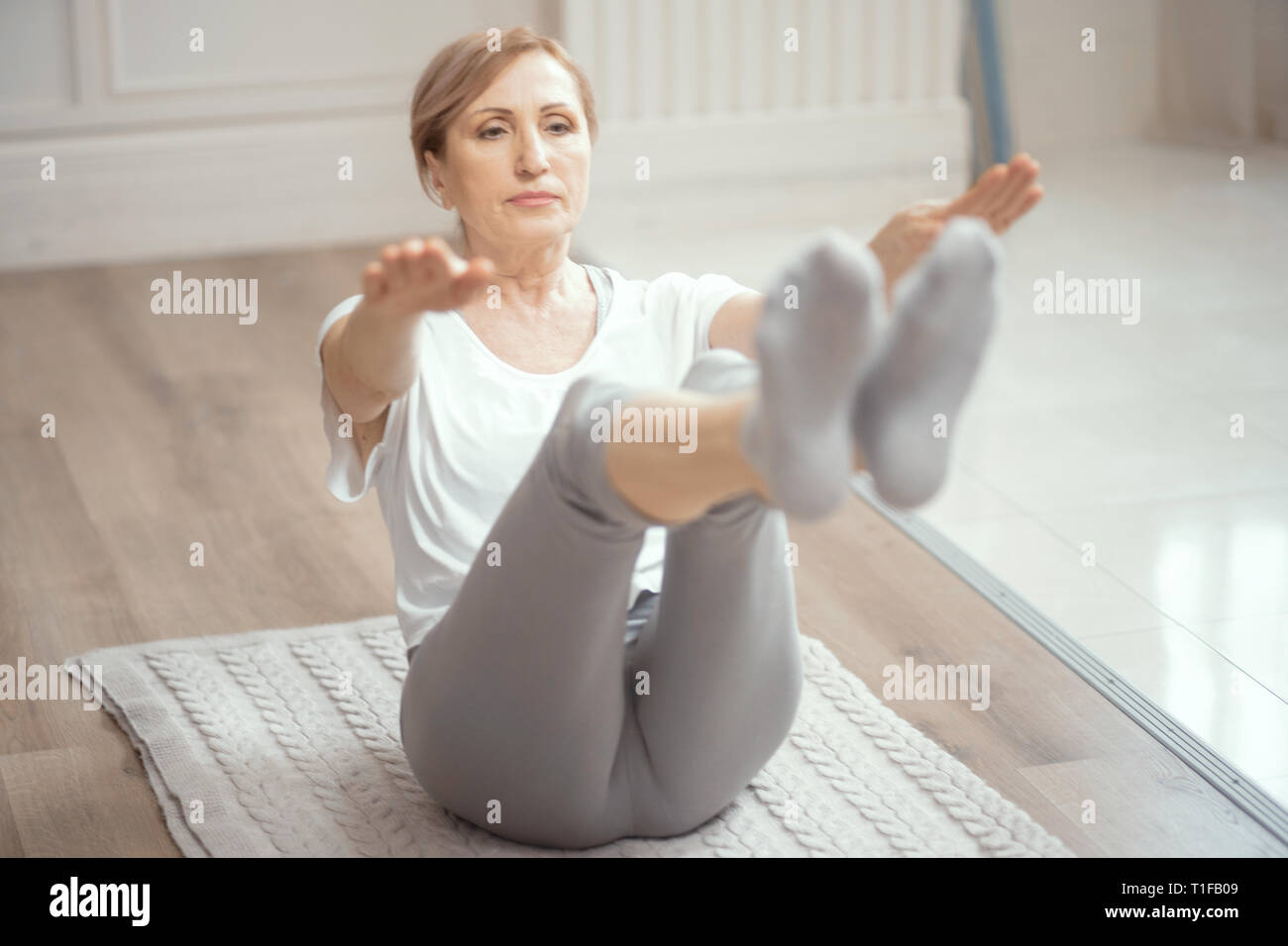 Allegra donna matura facendo esercizi yoga Foto Stock