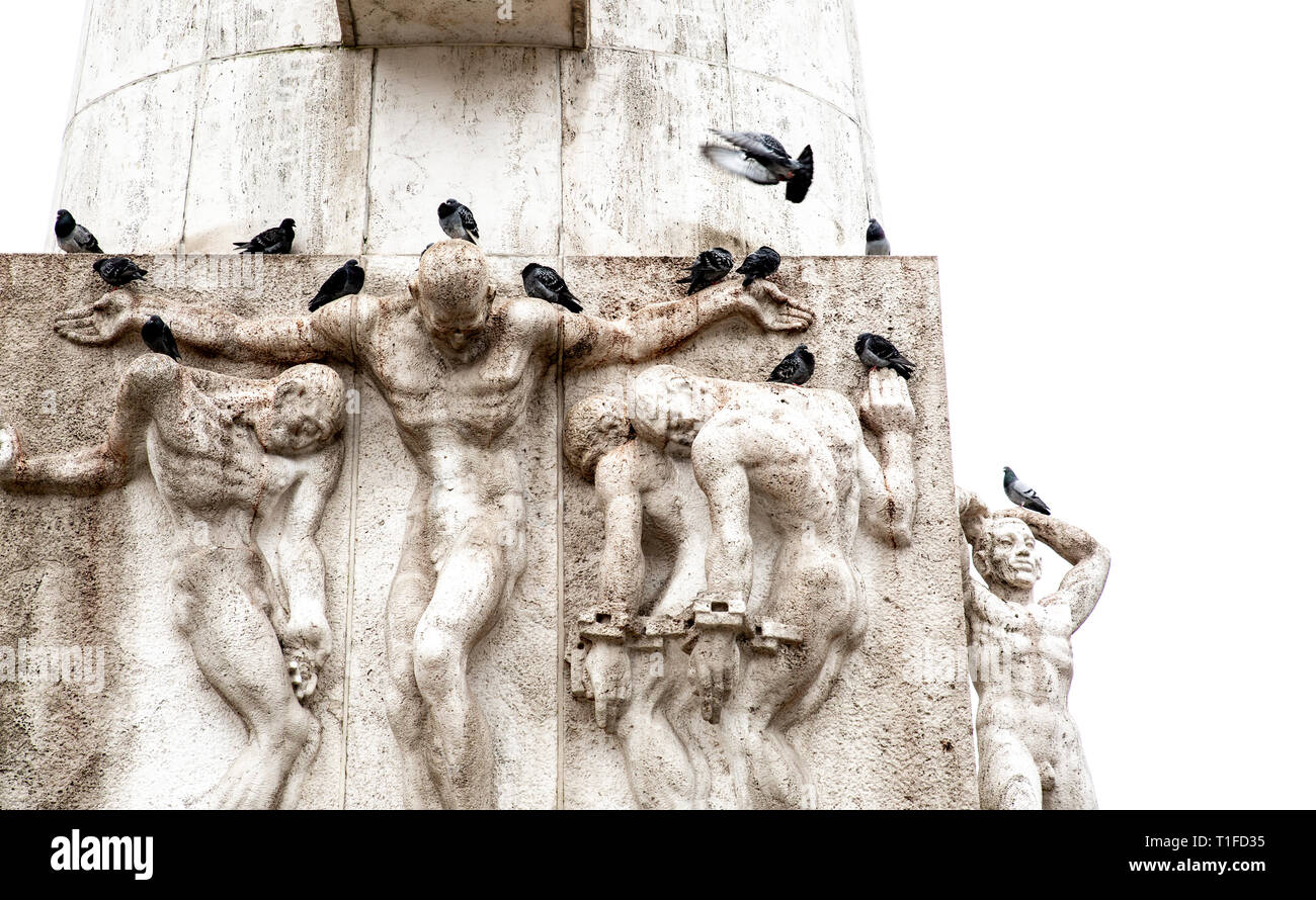 Dettagli delle sculture dell'obelisco di piazza Dam con piccioni in appoggio al di sopra Foto Stock