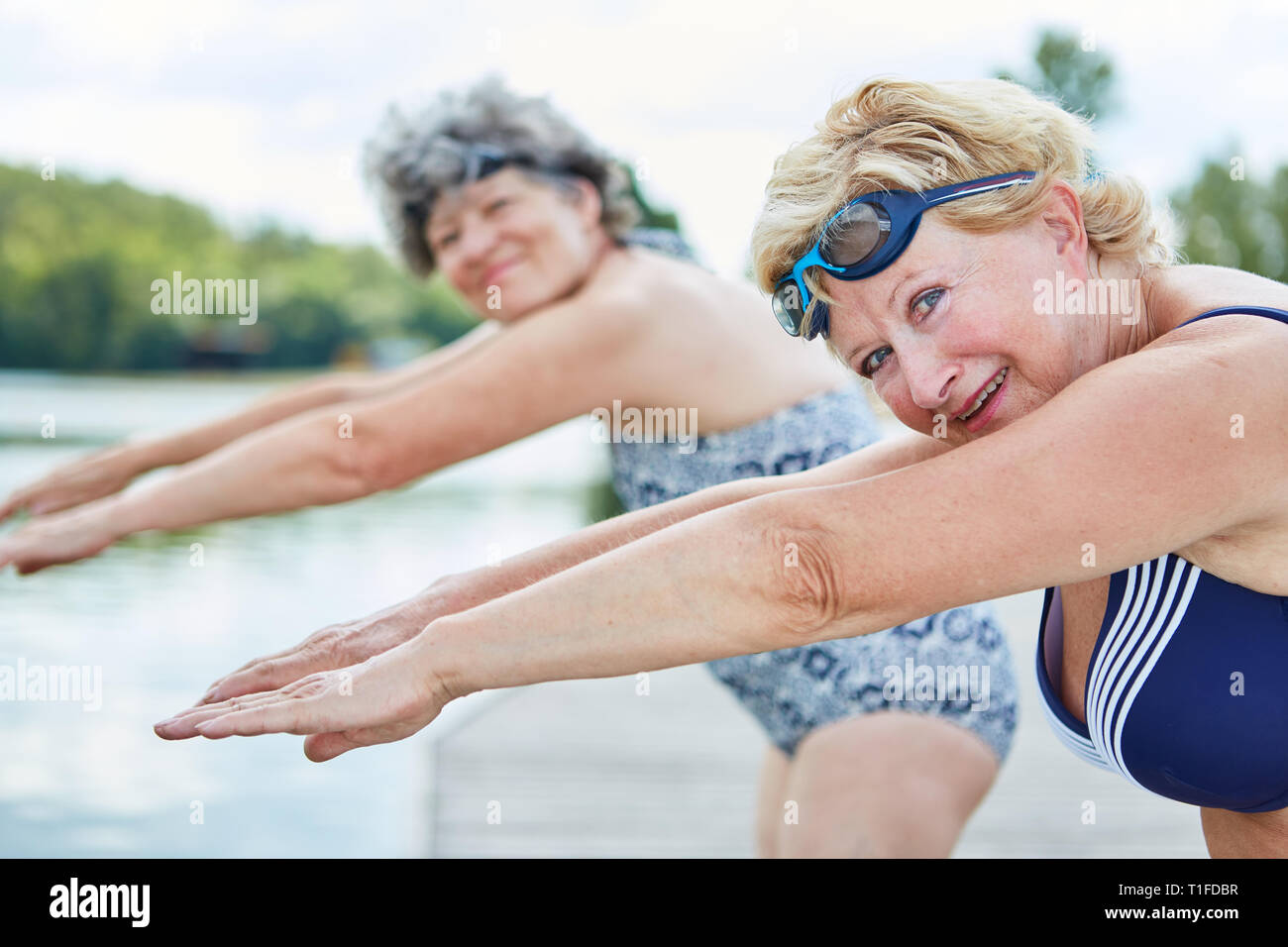 Due donne senior di andare a nuotare insieme e fare ginnastica sulla riva Foto Stock