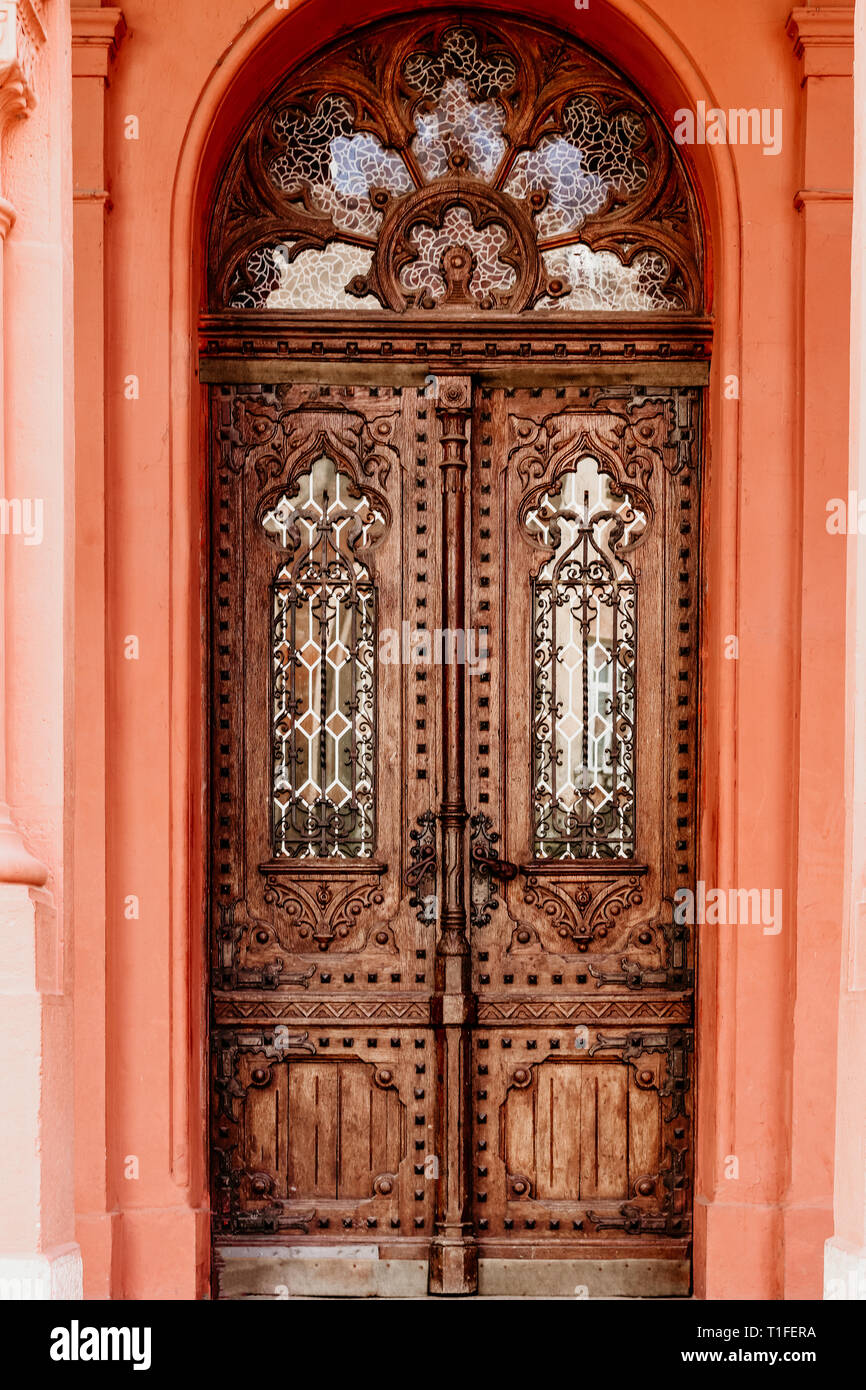 Legno marrone porta vecchia. Antica porta di legno nel muro di pietra. Foto Stock