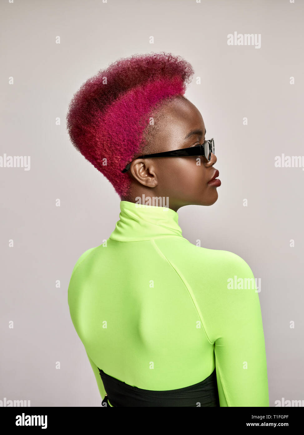 Close-up ritratto al coperto di incantevoli americano africano ragazza con i capelli colorati. Studio shot di grazioso giovane donna elegante con il taglio di capelli Foto Stock