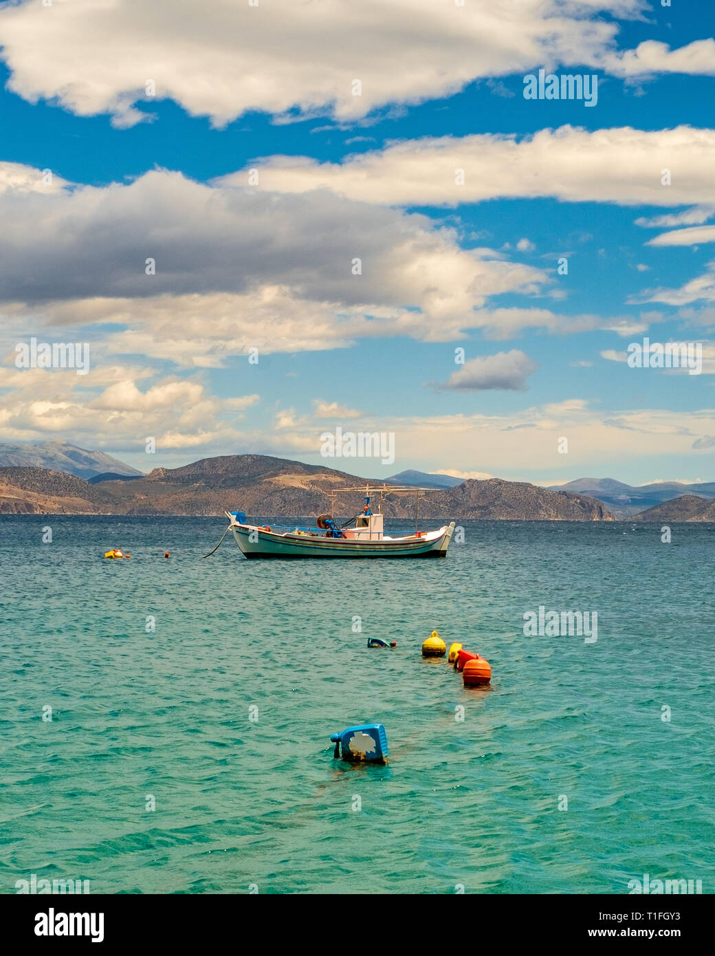 In legno barca da pesca galleggianti in una bella chiara acqua color smeraldo. Peloponneso, Grecia. Foto Stock