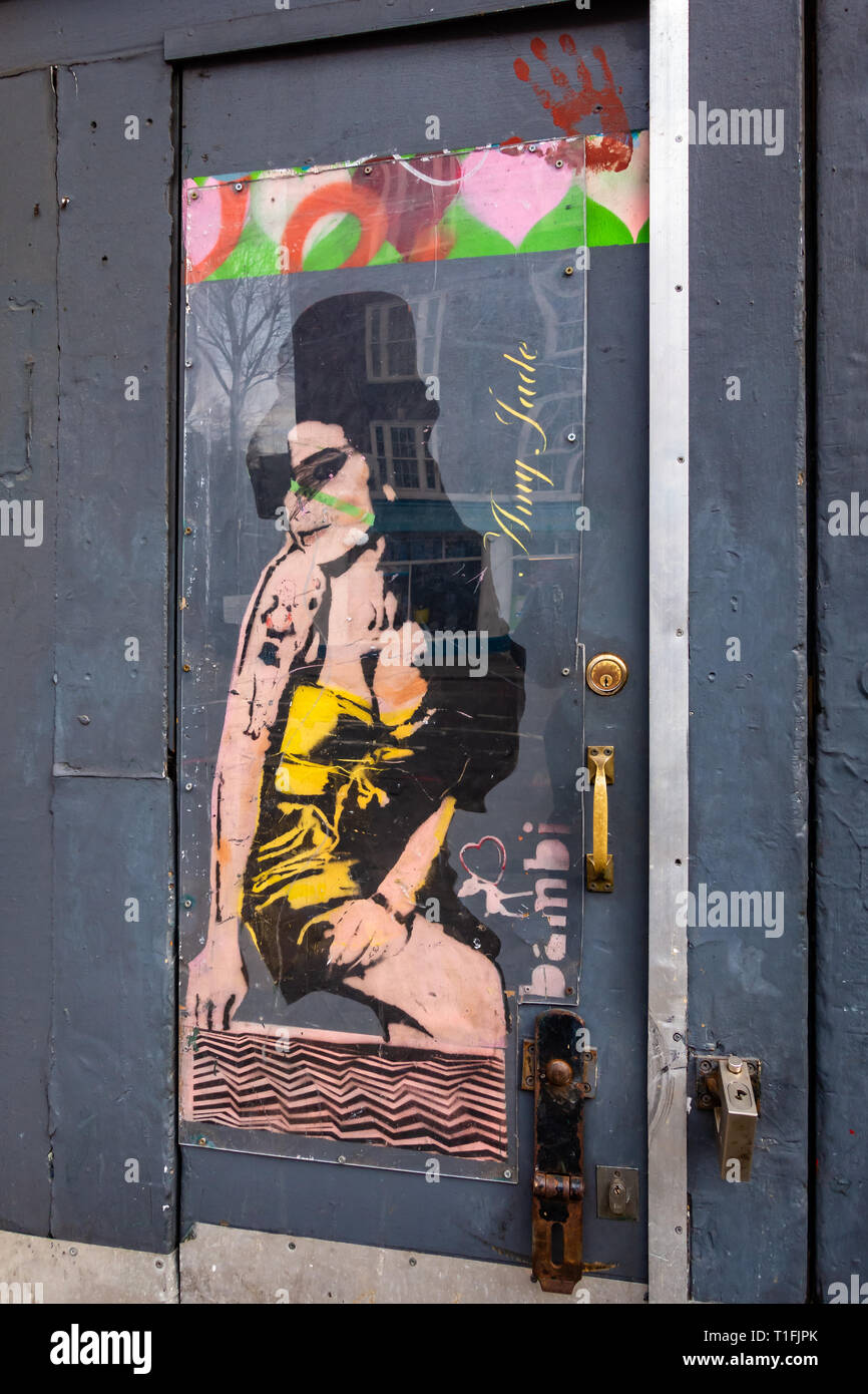 Edgy Graffiti arte dell'icona del pop cantante Amy Winehouse sulla porta a Camden Foto Stock