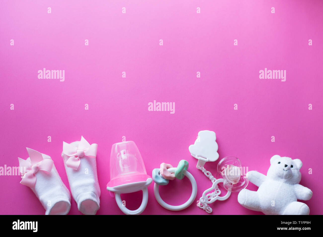 Baby accessori e giocattoli su sfondo rosa. Vista dall'alto. bambino laici piatta con il bianco dei giocattoli Foto Stock