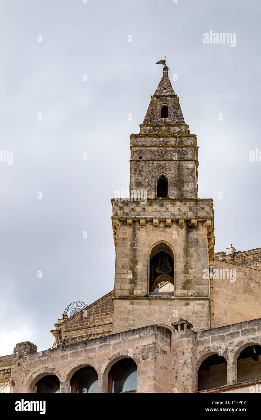 Il campanile della chiesa e il tetto con croce religiosa della Chiesa di Sant'Agostino, la vista della città antica di Matera, Basilicata, Italia meridionale, nuvoloso estate calda Foto Stock