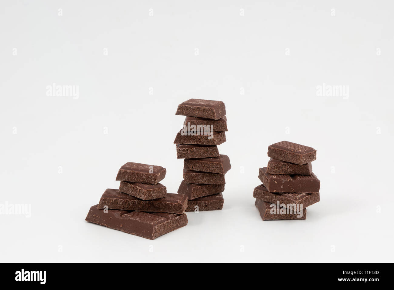 Una barra di cioccolato tritato su una superficie bianca Foto Stock