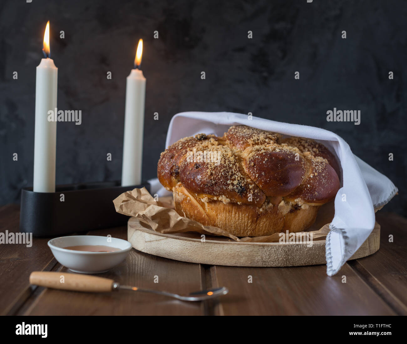 Dolce Challah pane su una collina boscosa piatto rotondo in legno marrone tabella con miele e due candele di Shabbat sera rendendo Kidush / sfondo nero con Foto Stock