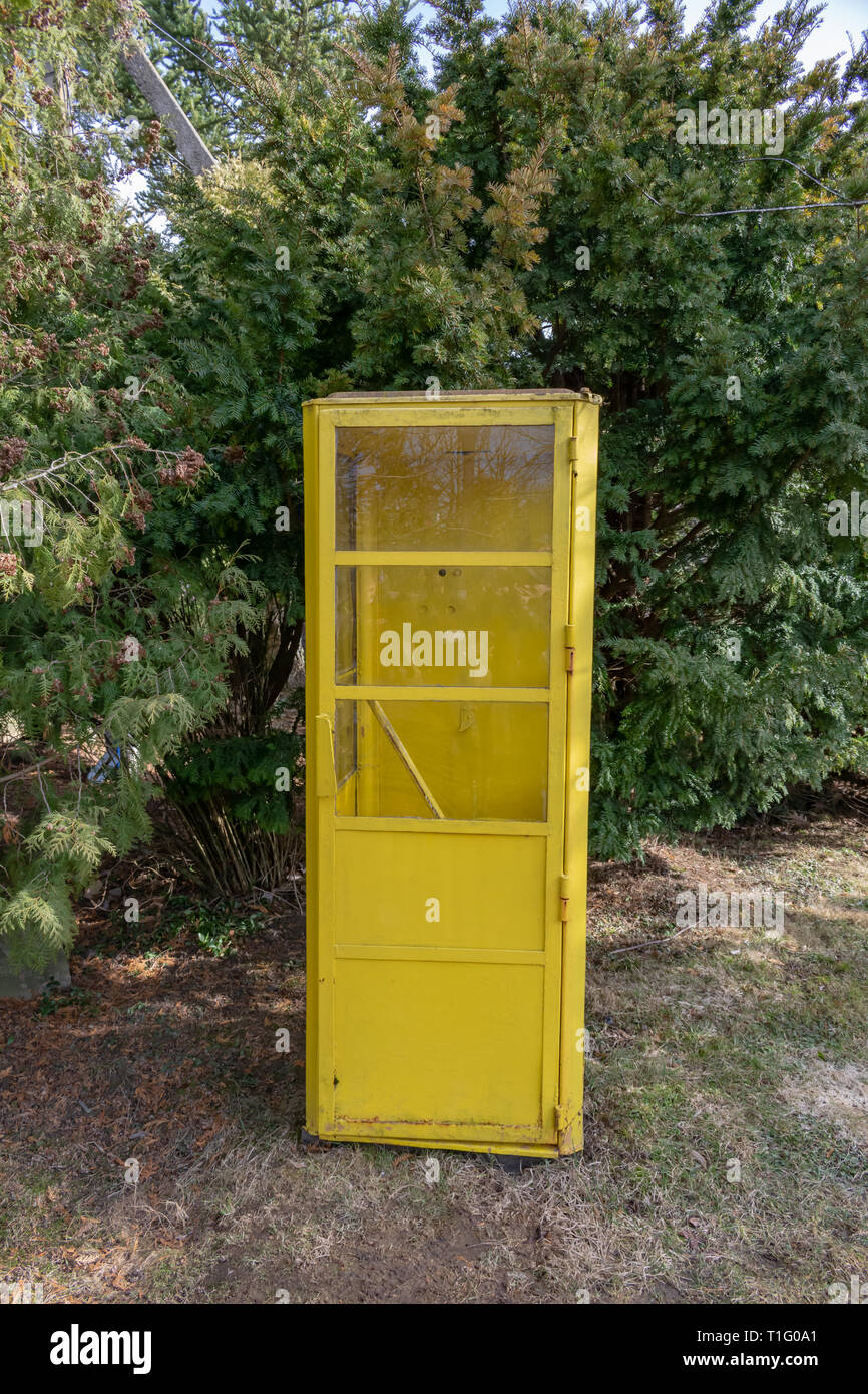 Vecchie gialle cabina telefonica in piedi all'aperto nel parco Foto Stock