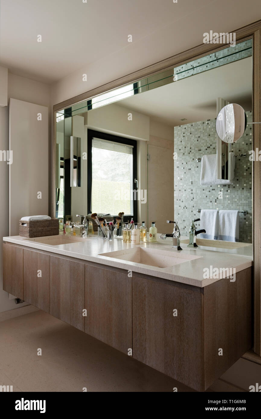 Specchio oltre il lavandino in bagno moderno Foto Stock