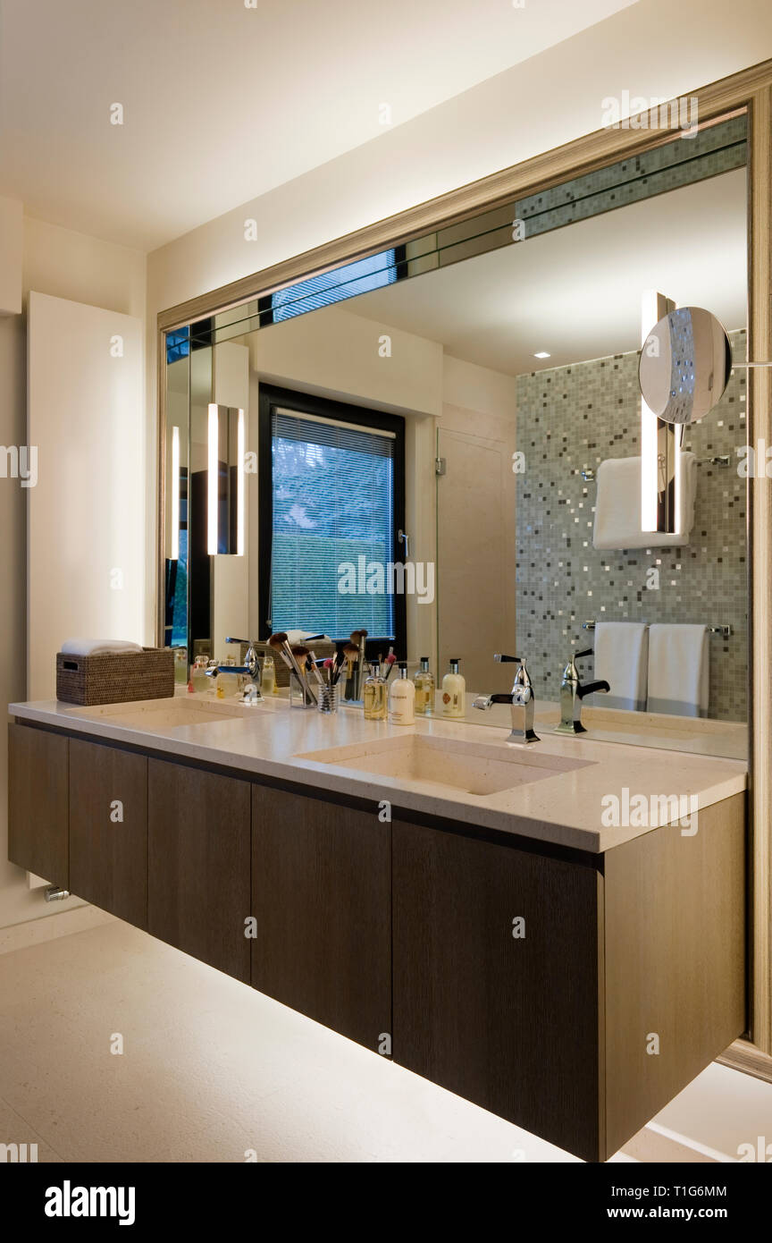 Specchio oltre il lavandino in bagno moderno Foto Stock