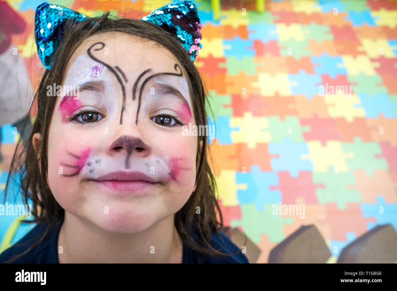 Bambino ragazza faccia di posa verniciate durante in sala giochi per bambini. Alta angolazione Foto Stock