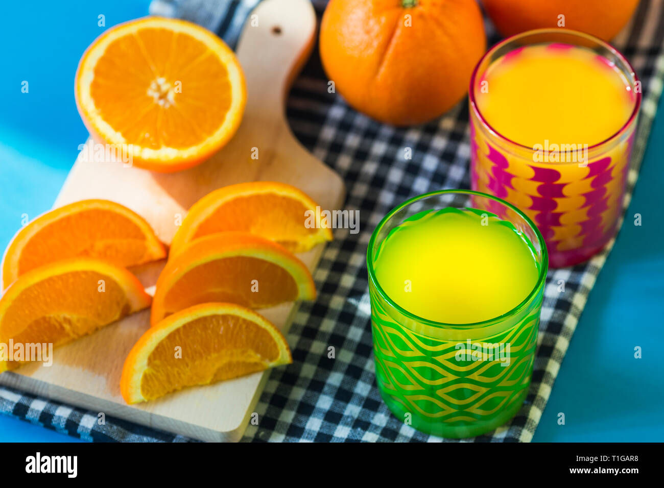 Succo di arancia e arance isolato su sfondo blu Foto Stock