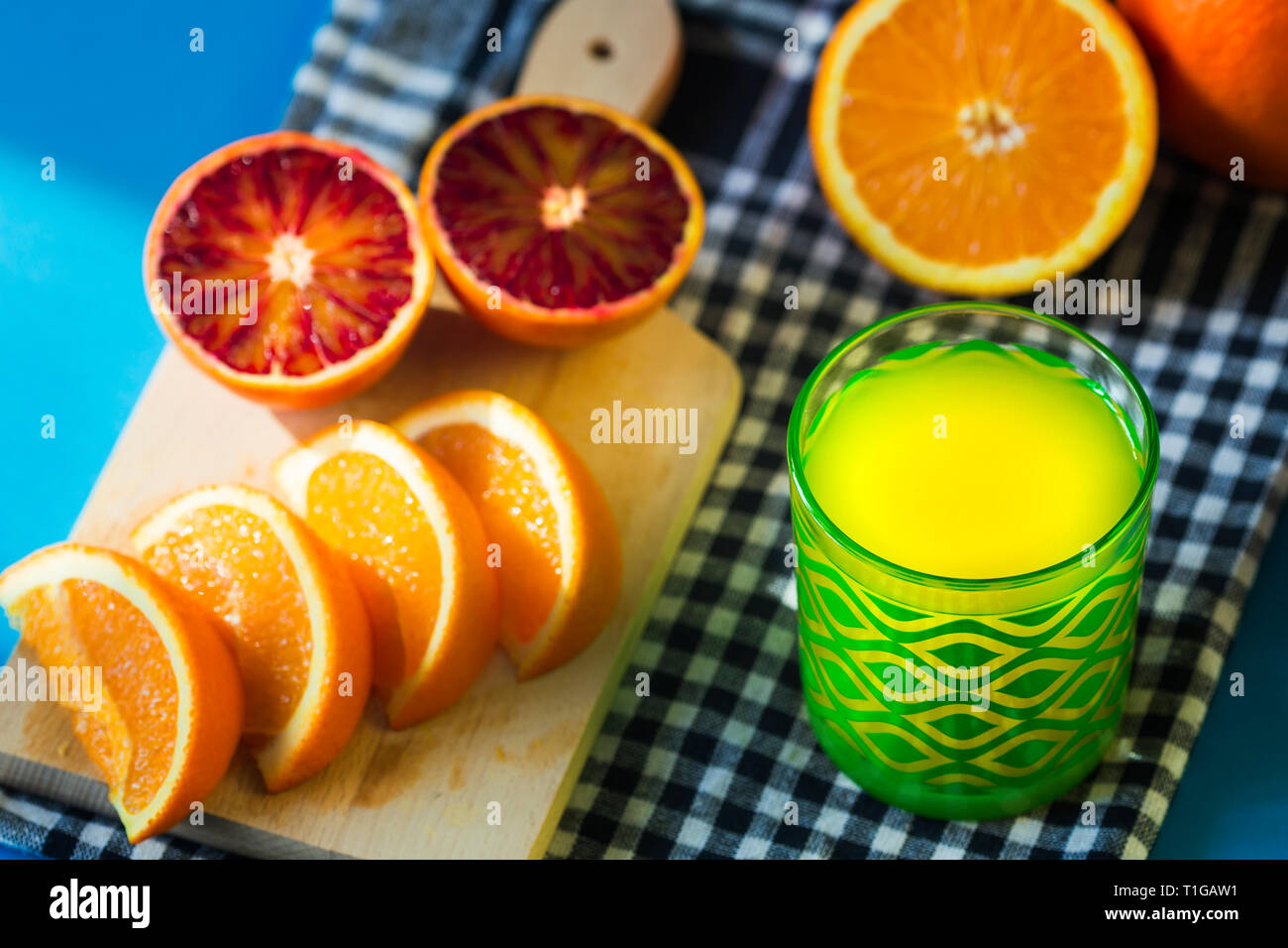 Succo di arancia e arance isolato su sfondo blu Foto Stock