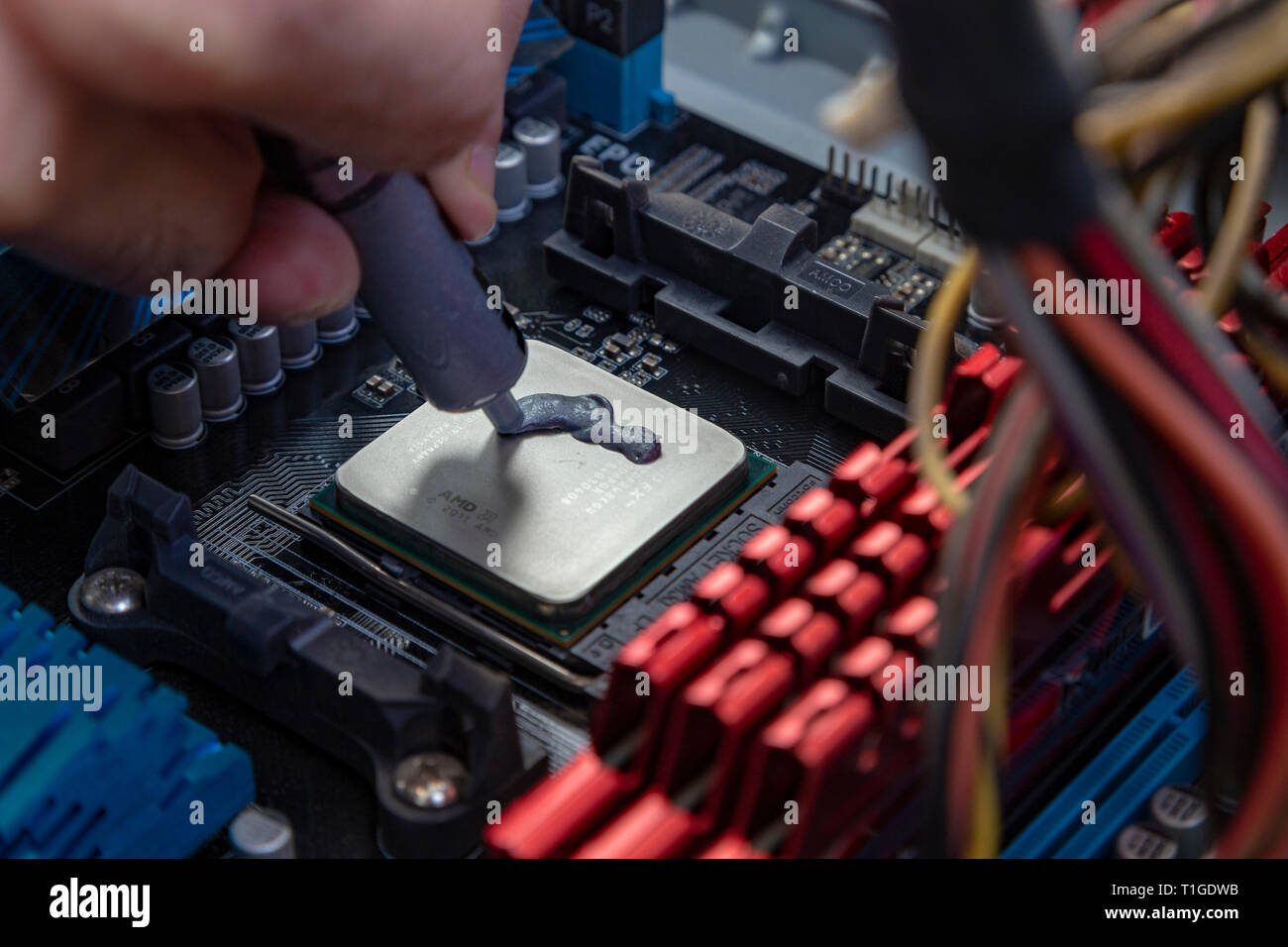 Ingegnere di applicare la pasta termica sul computer su chip della scheda cpu Foto Stock